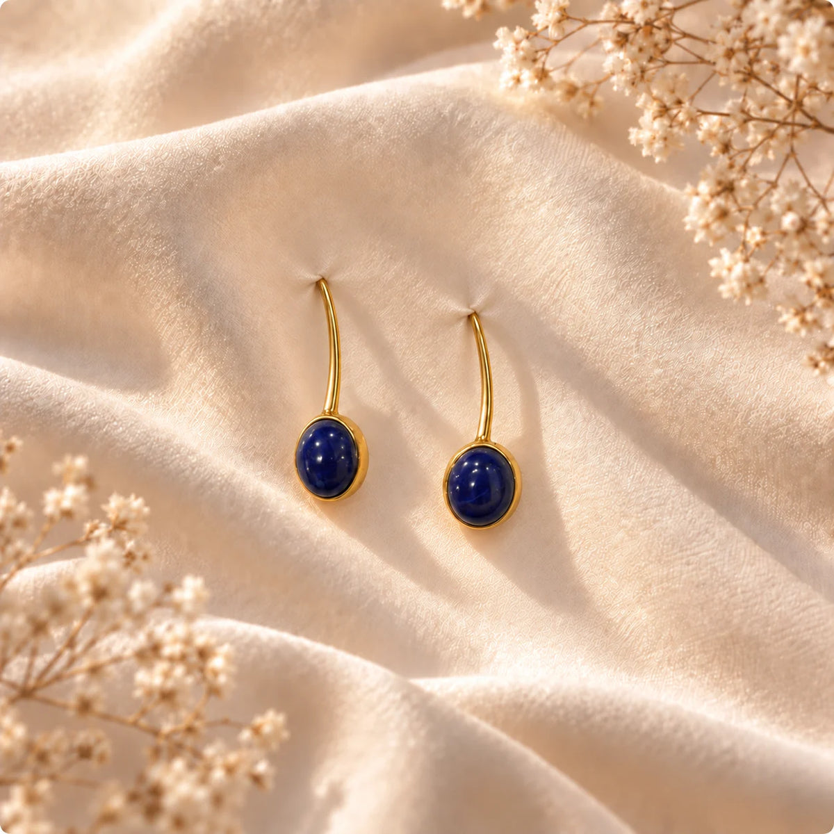 Slim gold plated earrings with a deep blue jasper set in an oval bezel. Ankkshi's Aakar collection.