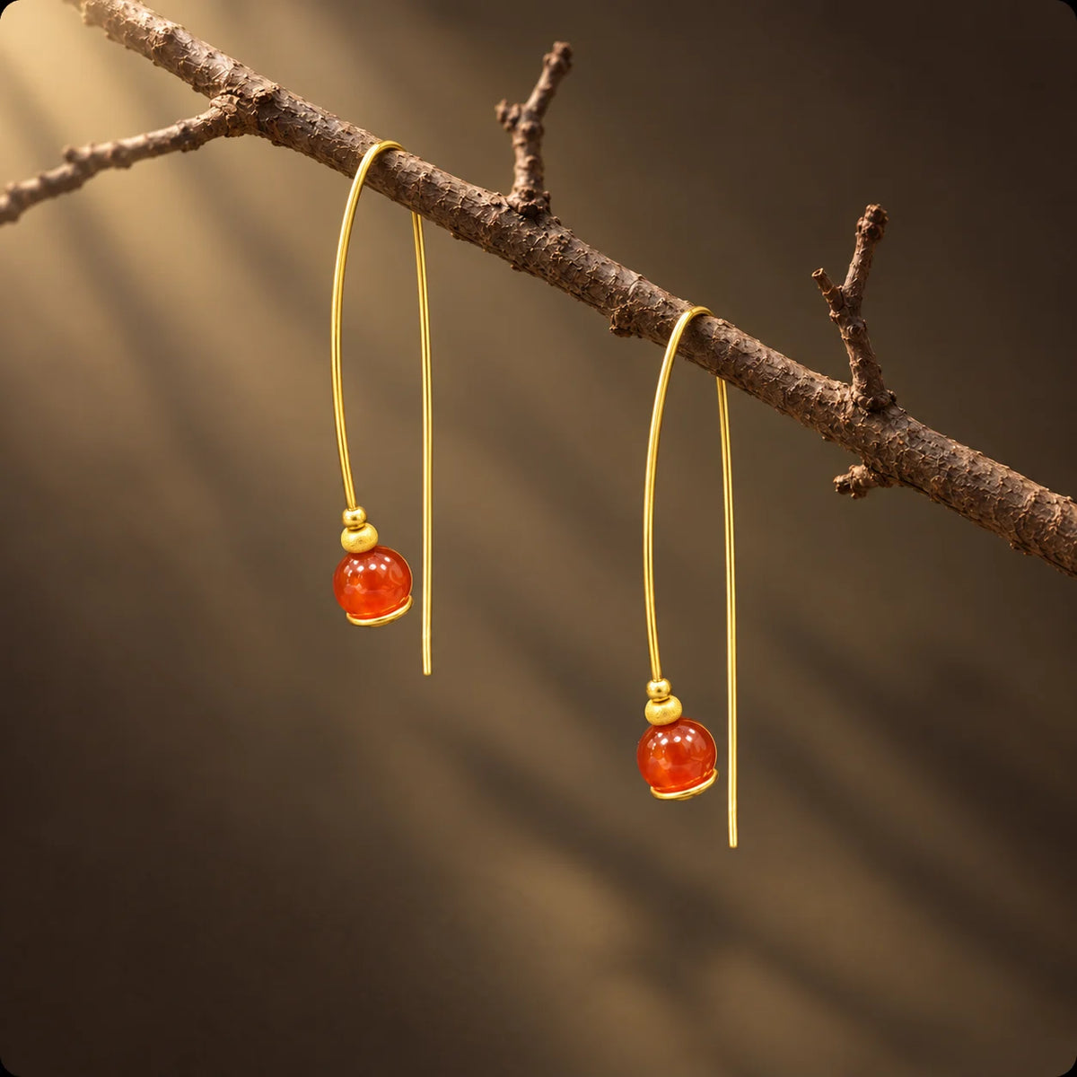 Minimal gold plated wire threader earrings with a warm carnelian bead accent. Ankkshi's Aakar collection.