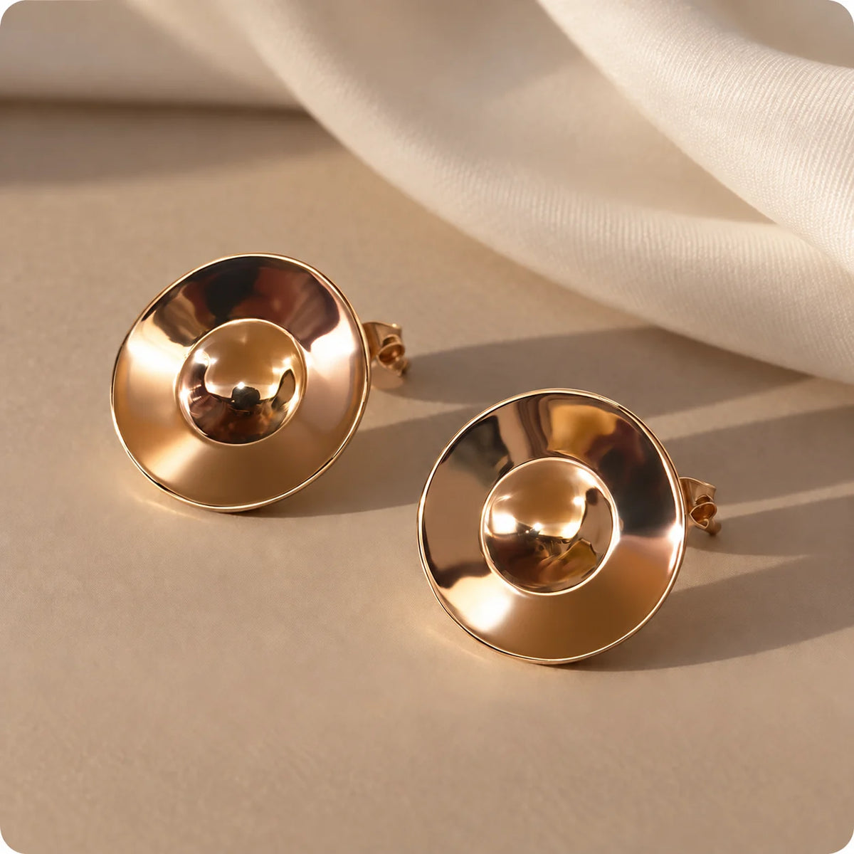Sculptural polished gold plated stud earrings with a domed centre and a softly dished disc. Ankkshi's Aakar collection.