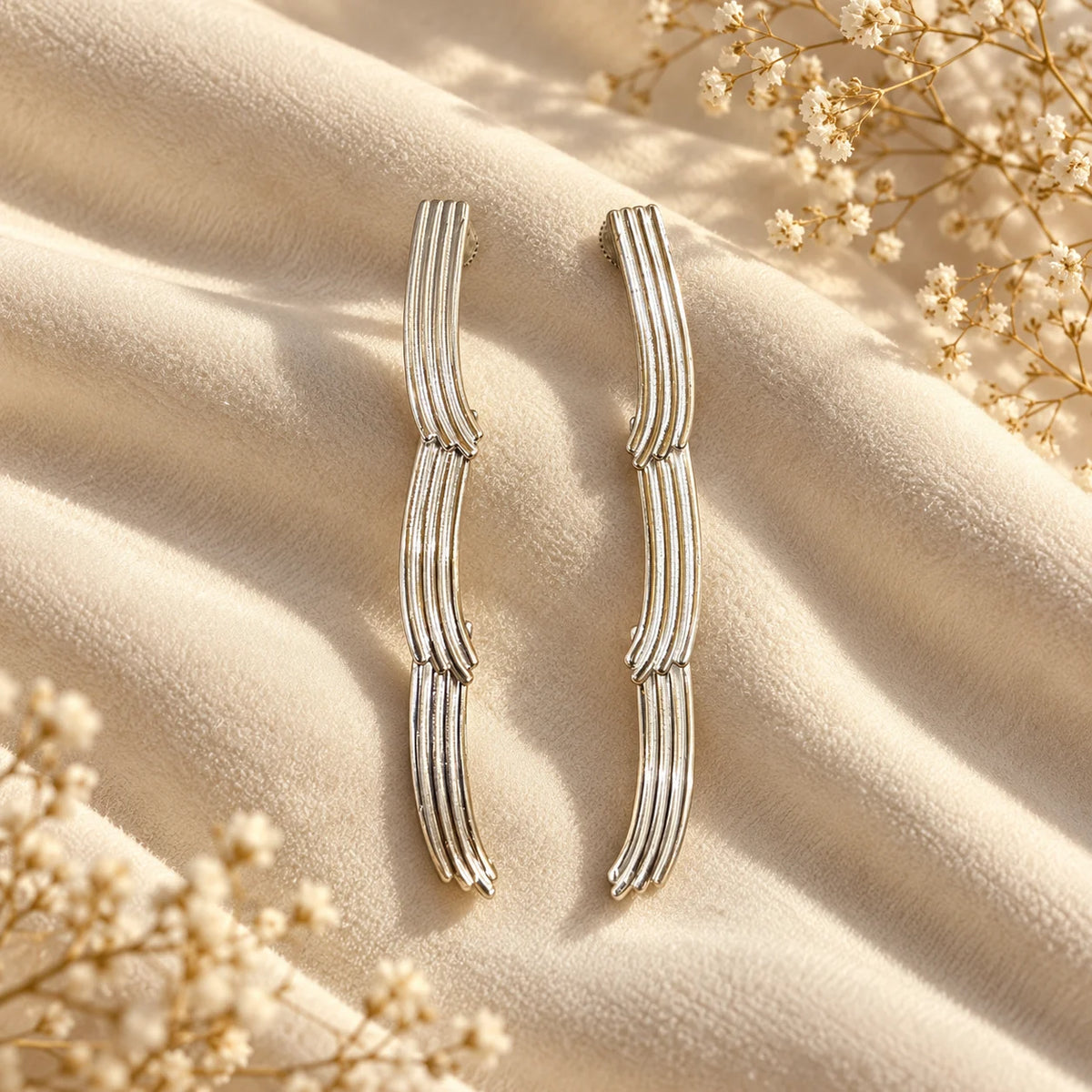 Minimal white gold plated ear climbers with ribbed, curved detailing. Ankkshi's Aakar collection.