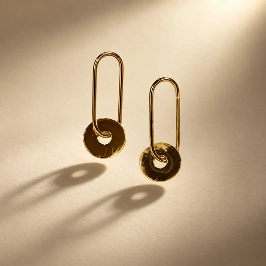 Minimal gold plated link earrings with a flat open-centre disc drop that swings softly. Ankkshi's Aakar collection.