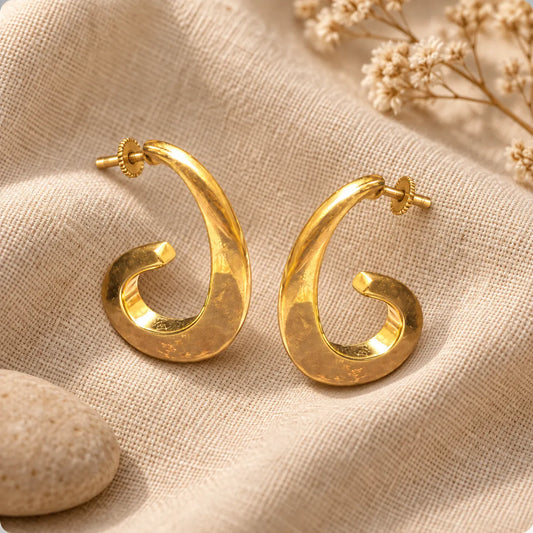 Bold sculptural gold plated hoop earrings with a sweeping curl and a high-shine finish. Ankkshi's Aakar collection.