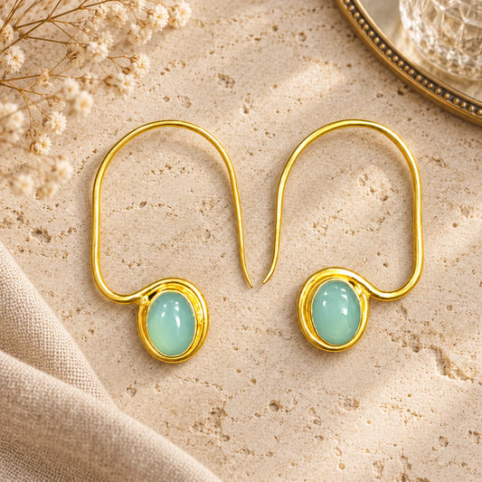 Sculptural 18k gold plated hook earrings with an oval chalcedony gemstone. Minimal design from Ankkshi's Aakar collection.