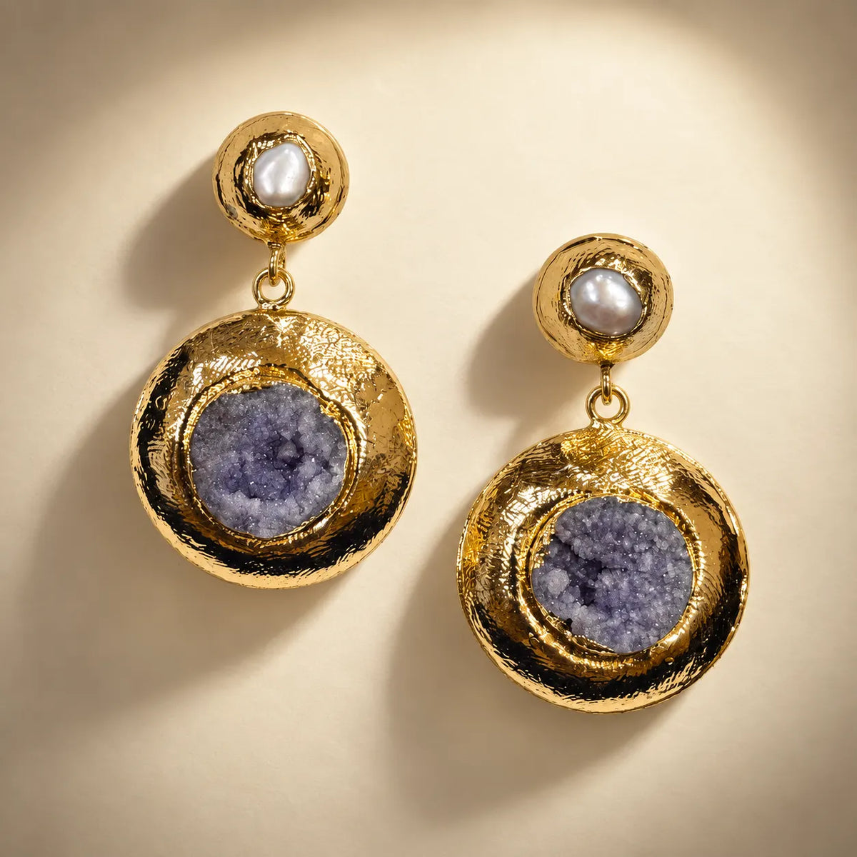 Hammered gold plated disc earrings with raw amethyst druzy and a freshwater pearl accent. Ankkshi's Aakar collection.