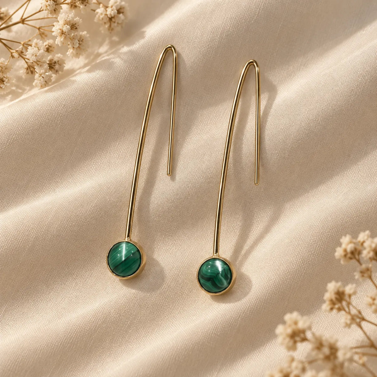 Slim gold plated wire earrings with a green malachite drop, its banded pattern unique to each stone. Ankkshi's Aakar collection.